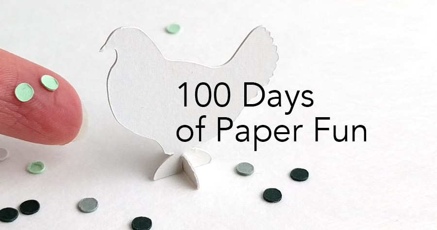 a hand holding a piece of paper with the words 100 days of paper fun on it