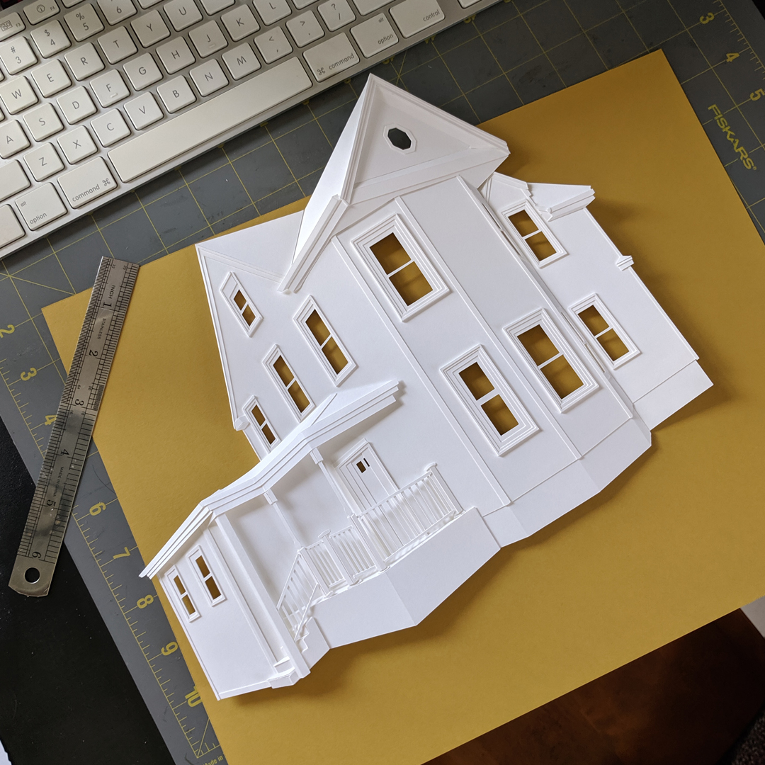a paper model of a house on top of a table
