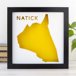 a black frame with a yellow map of the City of Natick