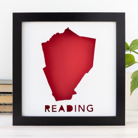 a red cut-out silhouette of the city of Reading, MA