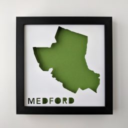 a black frame holding a cut out map of the state of medford