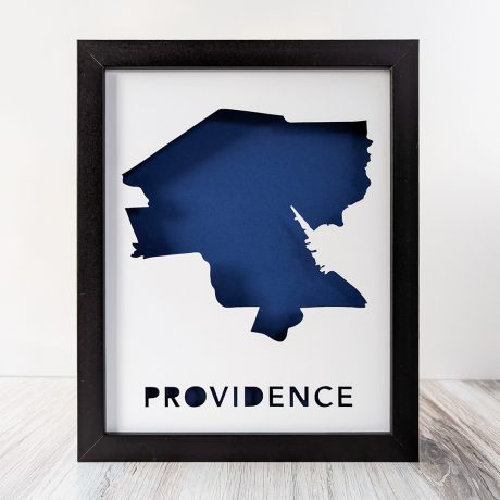 Framed art showing a cut-out in the shape of the City of Providence, RI with a dark blue background