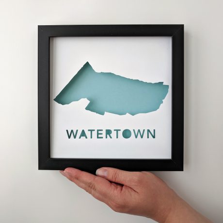 a hand holding a framed piece of paper that says watertown