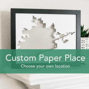 Framed map art with the words "custom paper place choose your own location" on a green overlay