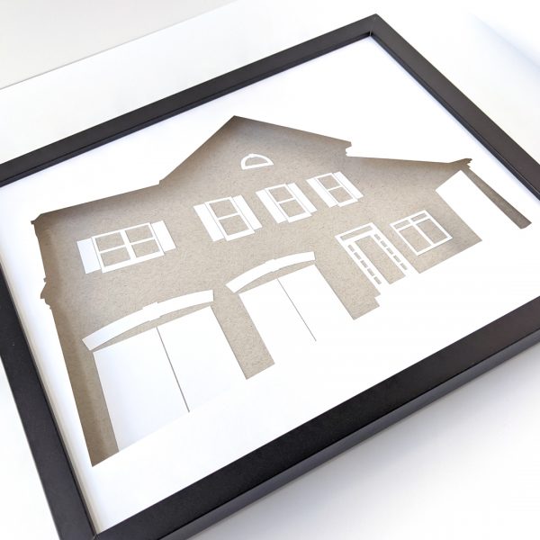 Framed custom house silhouette depicting a 2-story house with double garage, front porch, and sidelights around the front door
