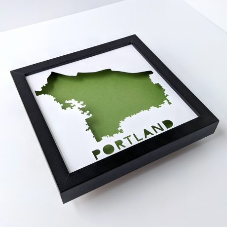 a black frame with a green map cut out of it