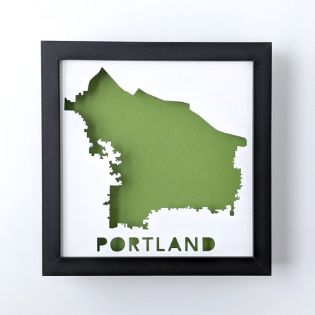 Framed map of Portland, Oregon cut from white paper to reveal a green background